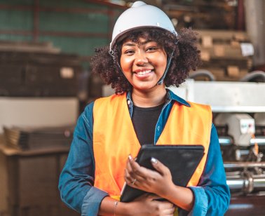 A smiling female security technician with a hard hat and tablet | HOME SECURITY INSTALLATIONS